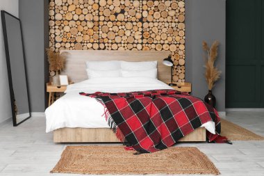 Modern ayna ve hasır halıları olan şık bir yatak odası.