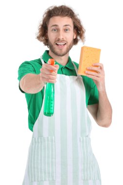 Beyaz arka planda temizlik süngeri ve deterjanı olan genç bir temizlik işçisi.