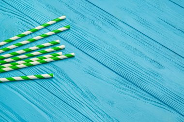 Mavi ahşap arka plandaki içecekler için şık pipetler