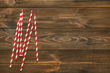 Ahşap arka plandaki içecekler için şık pipetler