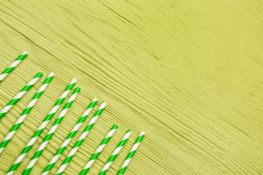 Yeşil ahşap arka plandaki içecekler için şık pipetler