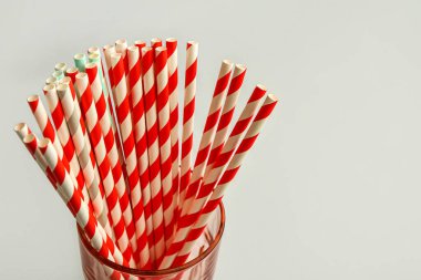 Hafif arka planda içecekler için şık pipetli cam.