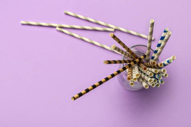 Mor arka plandaki içecekler için şık pipetli cam.