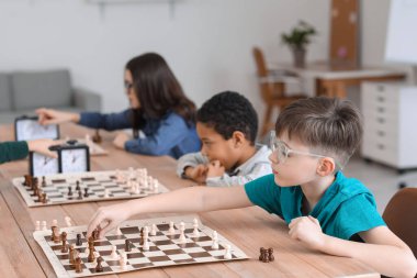 Kulüpte turnuvada satranç oynayan küçük çocuklar.