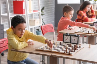 Kulüpte turnuvada satranç oynayan küçük çocuklar.