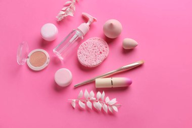 Pembe arka planda kozmetik ürünleri içeren kompozisyon