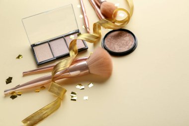 Açık renk arkaplanda kozmetik ürünleri ve makyaj fırçaları ile kompozisyon