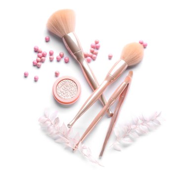 Beyaz arka planda farklı kozmetik ürünler ve makyaj fırçaları