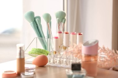 Masada farklı kozmetik ürünler ve makyaj fırçaları