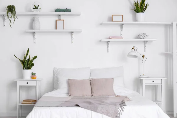 Comfortabel Bed Nachtkastjes Kamerplanten Lamp Nabij Witte Muur — Stockfoto