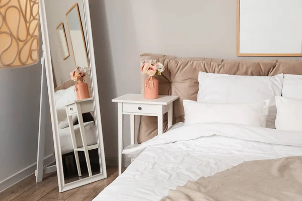 Comfortabel Bed Spiegel Nachtkastje Vaas Met Bloemen Bij Lichte Wand — Stockfoto