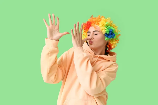 Αστεία Νεαρή Γυναίκα Πολύχρωμη Περούκα Πράσινο Φόντο Πρωταπριλιά Γιορτή Ημέρας — Φωτογραφία Αρχείου