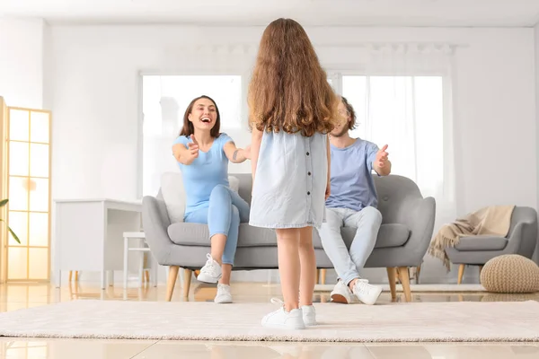 小さな娘立って反対側彼女の両親座っているソファ — ストック写真