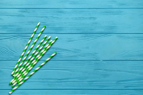 Mavi ahşap arka plandaki içecekler için şık pipetler