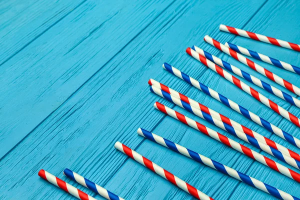 Mavi ahşap arka plandaki içecekler için şık pipetler