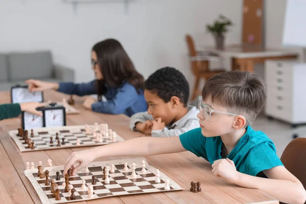 Kulüpte turnuvada satranç oynayan küçük çocuklar.