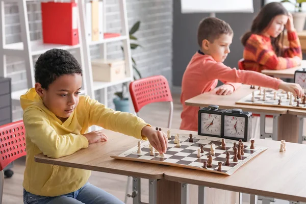 Kulüpte turnuvada satranç oynayan küçük çocuklar.