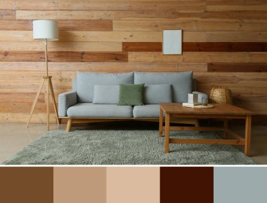 Ahşap duvarın yanında kanepesi, masası ve lambası olan modern oturma odasının içinde. Farklı renk örnekleri