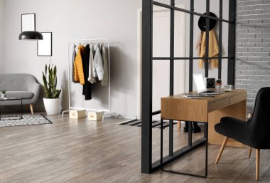 Şık bir çalışma odası ve ceketli bir askısı var.