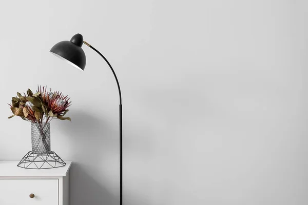 Vaas Met Bloemen Plank Zwarte Staande Lamp Buurt Van Lichtmuur — Stockfoto