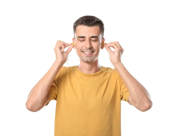 Smiling Young Man Yellow Shirt Putting Earplugs White Background — Stock Photo, Image