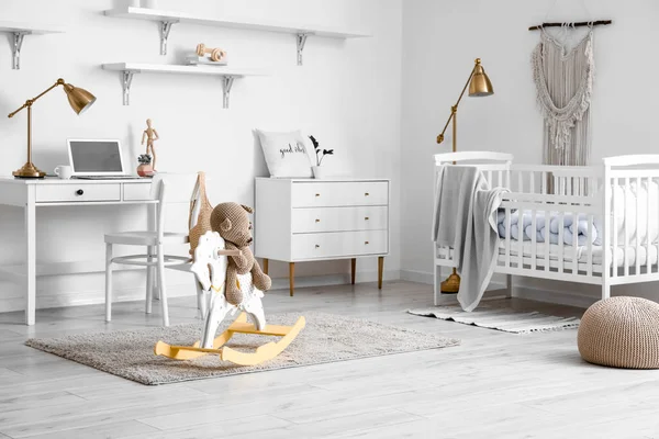 轻便儿童房的内部 有婴儿床 现代工作场所和玩具熊坐在摇马上 — 图库照片