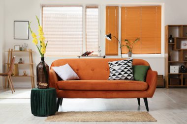 Rahat kanepesi ve gladyatör çiçekleri olan şık bir oturma odası.