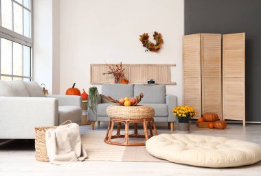 Rahat kanepeleri ve şık masaları olan modern oturma odasının içinde.