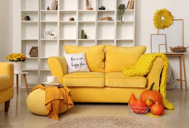 Rahat kanepe, taze balkabağı ve puf modern odada.