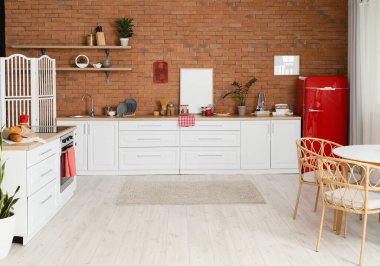 Modern mutfağın içinde şık buzdolabı ve tezgahlar var.