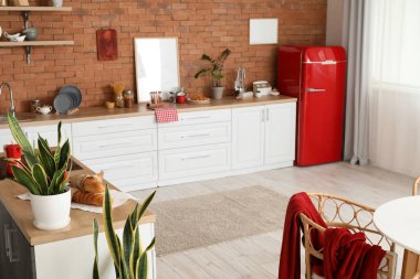 Modern mutfağın içinde şık buzdolabı ve tezgahlar var.