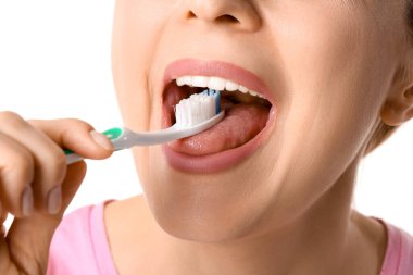 Güzel olgun bir kadın beyaz arka planda dişlerini fırçalıyor, yakın plan.