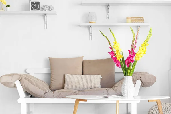 快適なソファとグラジオラスの花とスタイリッシュなリビングルームのインテリア — ストック写真