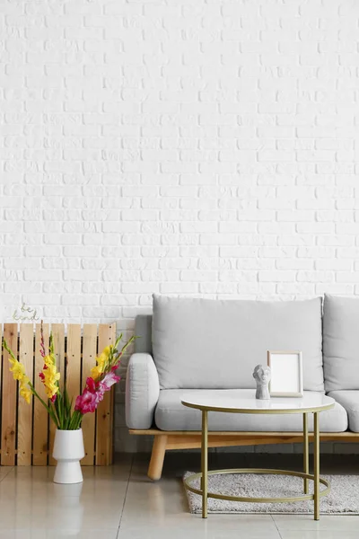 Comfortable Sofa Vase Beautiful Gladiolus Flowers White Brick Wall — Stock Photo, Image