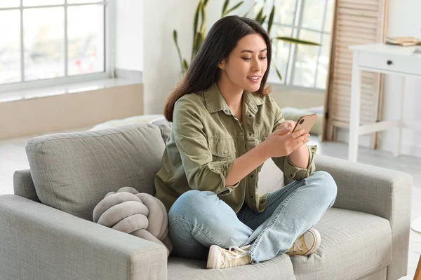 Vacker Ung Asiatisk Kvinna Med Mobiltelefon Sitter Soffan Hemma — Stockfoto