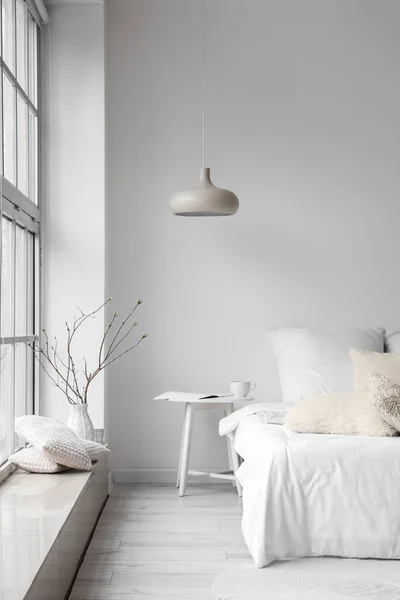 光の部屋のインテリアの白い壁の近くの快適なベッド — ストック写真