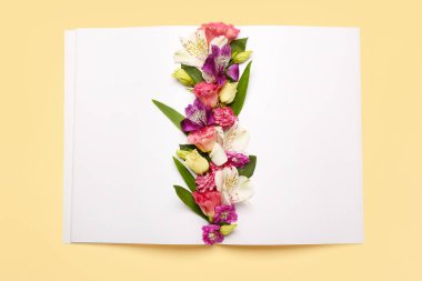 Renkli arka planda güzel çiçekler olan boş bir kitap