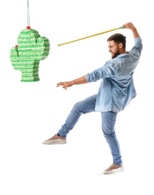 Beyaz arka planda Meksika pinatasını kıran yakışıklı adam.