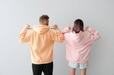 Hafif arka planda kapüşonlu, havalı genç bir çift.