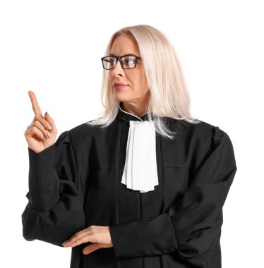 Gözlüklü olgun kadın yargıç beyaz arka plandaki bir şeyi işaret ediyor.