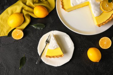 Lezzetli limonlu turta ve siyah arka planda taze meyve tabağı.