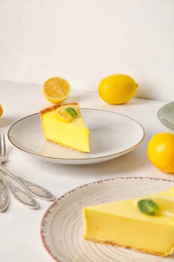 Lezzetli limonlu turtalar ve beyaz arka planda taze meyveler.