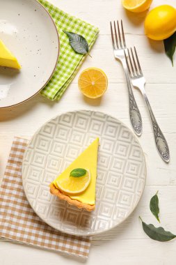 Lezzetli limonlu turtalar ve beyaz ahşap arka planda taze meyveler.