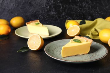 Lezzetli limonlu turtalar ve siyah arka planda taze meyveler.