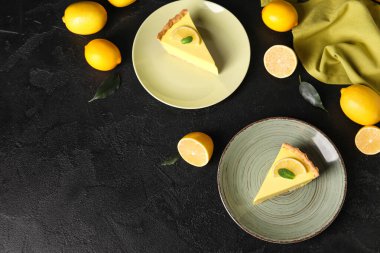 Lezzetli limonlu turtalar ve siyah arka planda taze meyveler.