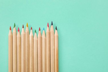 Turkuaz arka planda renkli kalemler