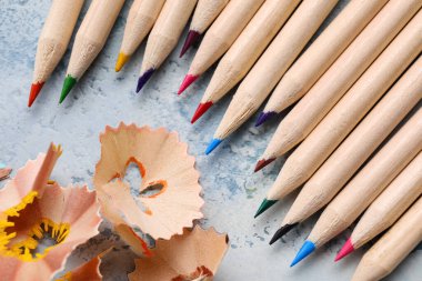 Mavi grunge arka planında renkli kalemler ve talaşlar