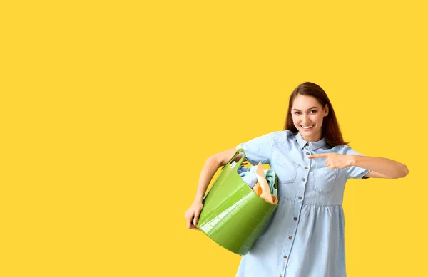 Όμορφη Γυναίκα Δείχνει Πράσινο Καλάθι Πλυντήριο Κίτρινο Φόντο — Φωτογραφία Αρχείου