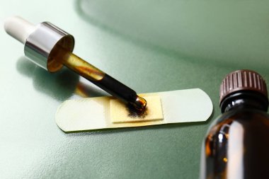 Şişe, iyot ve yeşil arka planda tıbbi sıvalı pipet.