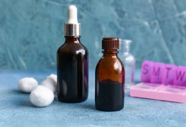 İyotlu şişeler, pamuk topları ve mavi arka planda haplar.